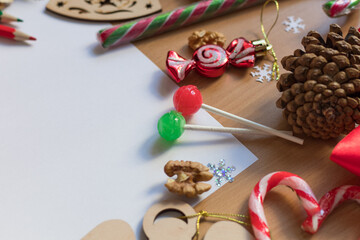 Blank white sheet of paper surrounded with festive christmas decorations. Merry Christmas and Happy New Year. Xmas concept. Top view. Copy space.