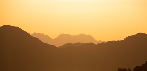 Mountain range silhouette in warm sunset colors
