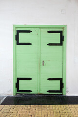 Obraz na płótnie Canvas Old green wooden door in white wall, background photo
