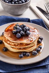 American breakfast. Stack of homemade american pancakes with fresh berry and pouring maple syrup on a white background. Fresh blueberries. Food photo. Breakfast photo. Recipe. Fluffy. Close up view