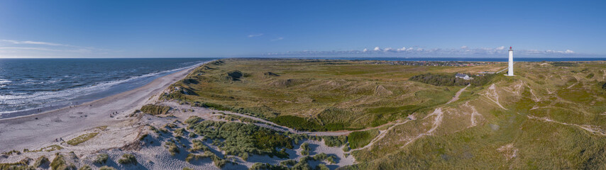 Panoramic aerial view of Lyngvig lighthouse on wide dune of Holmsland Klit with beach view on the...