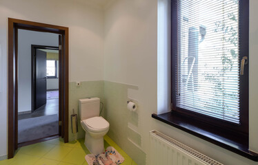Contemporary interior of bathroom in private house. Wooden door and toilet.