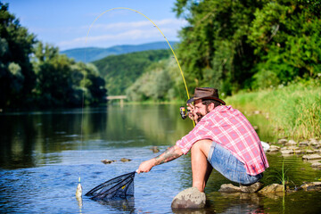 big game fishing. relax on nature. hipster fishing with spoon-bait. fly fish hobby of man. Hipster...