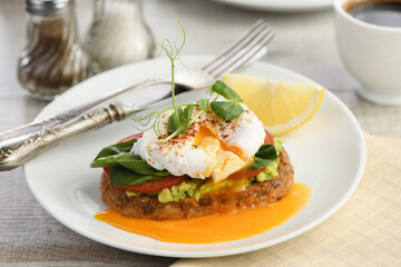 Eggs Benedict with guacamole on cereal bread