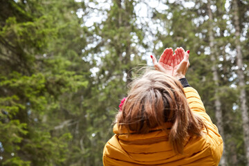 Woman with praying hands enjoying good vibes in the nature.
