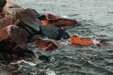 waves hitting stones on the shore in the black sea during a storm - 384132283