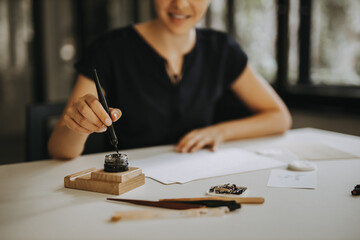 Woman writing a note with fountain pen.