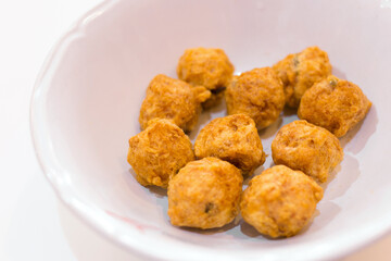 Fried premium shrimp ball made from fresh shrimp suitable to be served with noodles on a white plate. Selective focus with shallow depth of field on the top view. Delicious crispy shrimp balls.