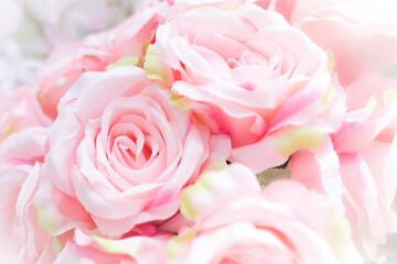 Close up of many fabric pale pink roses with blurred  background.