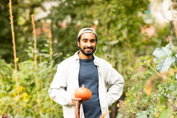 Junger Mann mit Kürbis und Mütze in einem urbanic Garden