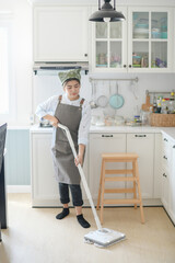 A young maid cleaning the house with a mop There is a kitchen backdrop