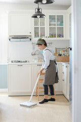 A young maid cleaning the house with a mop There is a kitchen backdrop