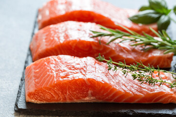Salmon. Fresh raw salmon fish fillet with cooking ingredients, herbs and lemon. Close up. healthy food, diet or cooking concept