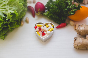 colorful medicine pills in form of heart on the white background