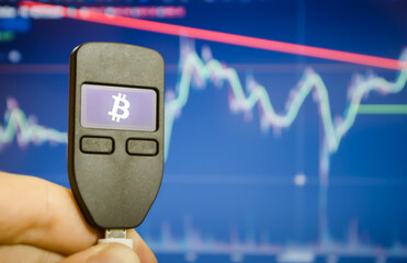 Close-up of a male hand holds a wallet for storing e-money, bitcoin graphic. - 384136675