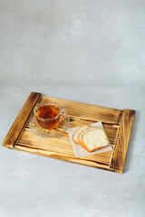 Couple of pieces of handmade fresh muffin chopped on a wooden serving board and cup of tea breakfast on stylish background