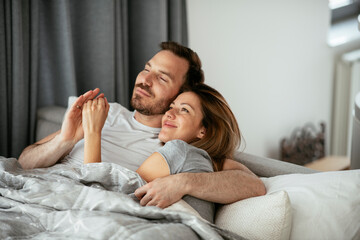 Young loving couple in bed. Happy couple relaxing in bed.Young loving couple in bed. Happy couple relaxing in bed.