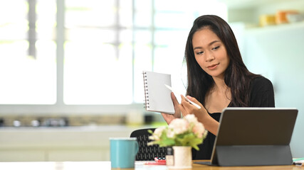 Young Asian businesswoman conference of colleagues through a tablet.