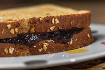 Breakfast. Peanut butter and raspberry jelly sandwich on wooden background.