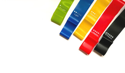 Set of colorful latex rubber bands for fitness on a white background.  Sports concept.  Home fitness workout trend.  Top view, flat lay, copy space, isolate.