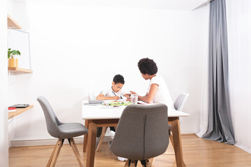 Fototapeta premium Mother helping son with studies