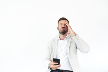 Depressed businessman holding phone with head in hands