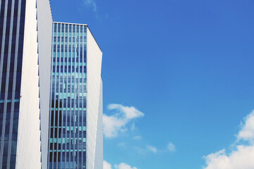 building with blue clear sky background, lookup to the angle of the corner building, business building background