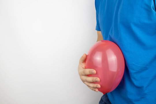 Bloating and flatulence concept. The man holds a red balloon near the abdomen, which symbolizes gas problems. Intestinal tract and digestive system
