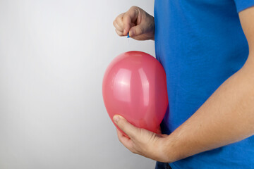 Conceptual photography. The man holds a red ball near his belly, which symbolizes bloating and...