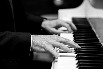 Caucasian male playing a grand piano