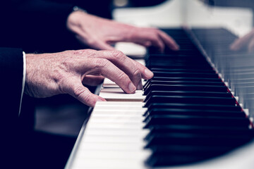 Caucasian male playing a grand piano
