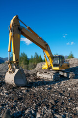Excavator in a mountainous area in an industrial area in a working pause
