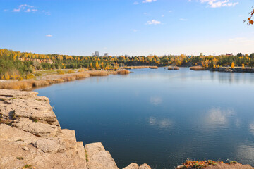 Fototapeta premium Beautiful old granite quarry with clear water in Indian summer. Chelyabinsk, Russia.