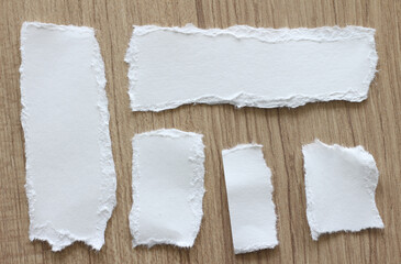 pieces of torn paper on wood background with copy space for text