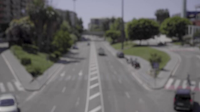 Unfocused image of an avenue during the day in a city where cars circulate.