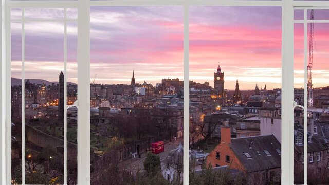 edinburgh landscape as seen from a white window while birds are flying. It is seen the city at the sunset with royal mile, and clockwork tower in the background