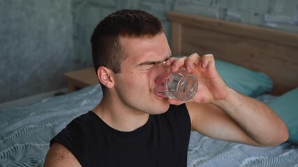 man drinks vodka from a glass in one gulp