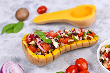 Vegan baked Butternut squash vegetable filled with bell pepper, cherry tomatoes, red onion and mushrooms