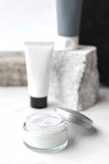 Mock up. Jars, tubes of cream or body lotion, white and gray, on pieces of stone on a white background. Natural eco organic cosmetics. Treatment spa beauty skincare. Healthcare, medicine. Product ad
