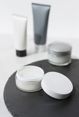 Mock up. Jars, tubes of cream or body lotion, white and gray, on pieces of stone on a white background. Natural eco organic cosmetics. Treatment spa beauty skincare. Healthcare, medicine. Product ad