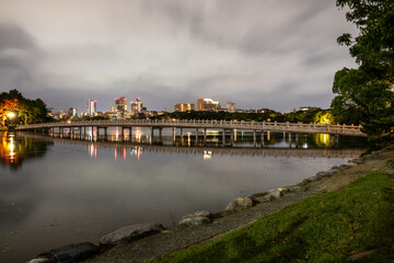 Fototapeta premium Ohori Park, a city park in central Fukuoka with a large pond at its center, in cloudy day in dark mood. The present park was modeled on the West Lake of China and opened in 1929