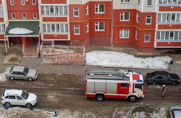 Fototapeta na wymiar Fire engine in the courtyard of a multi-storey residential building in winter.