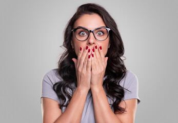 Shocked woman in glasses covering mouth - obrazy, fototapety, plakaty