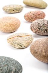 Fototapeta na wymiar Studio photo of stacked, natural stone pebbles isolated on white background with soft shadow.