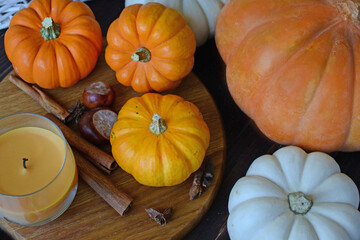 autumn layout for Thanksgiving and Halloween. harvest. composition of white and orange pumpkins of different sizes. cinnamon sticks, chestnuts, candles, wooden table