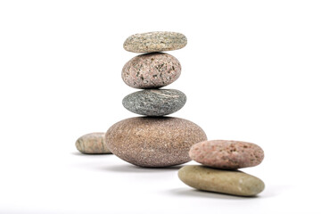 Studio photo of stacked, natural stone pebbles isolated on white background with soft shadow.
