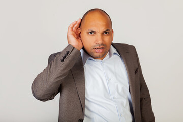 Man African American businessman, holding his hand behind his ear, showing that he does not hear,...