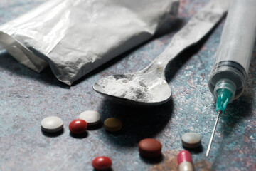 drug addiction concept with heroine packet and syringe on black backgrund 
