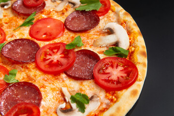 pizza with tomatoes, pepperoni and herbs