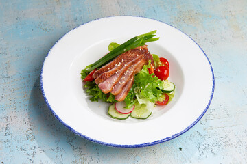 salad with duck and herbs in a plate